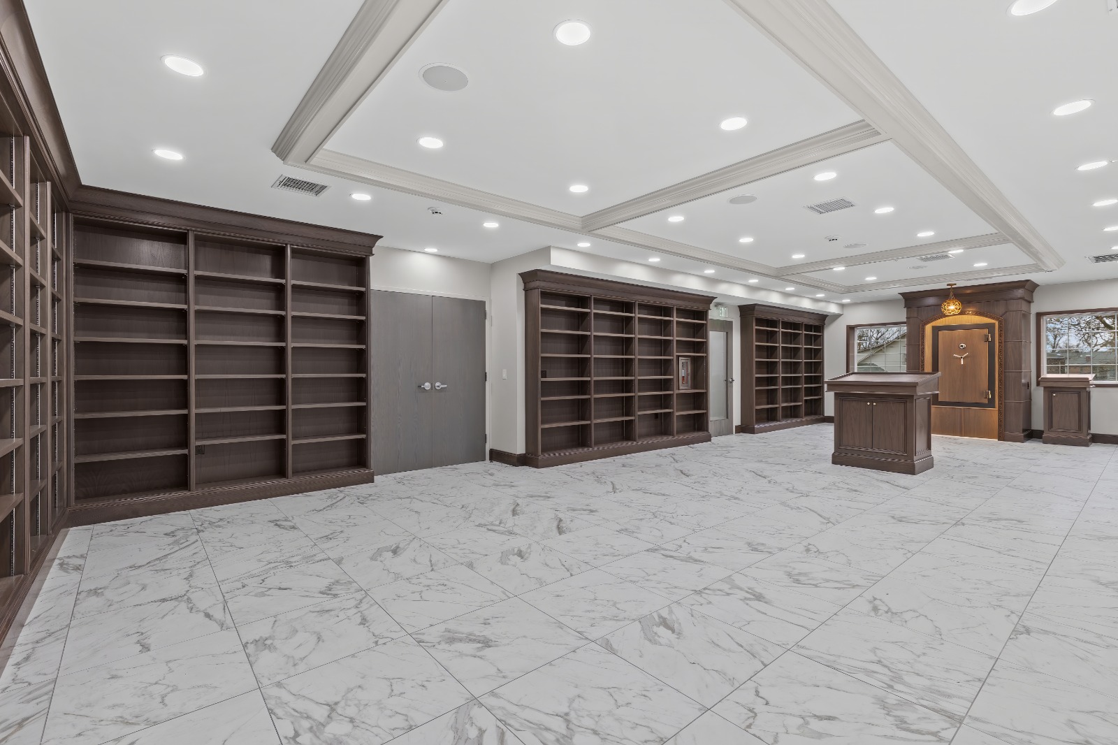 Commercial hall with marble floors, recessed lighting, and custom wood shelving