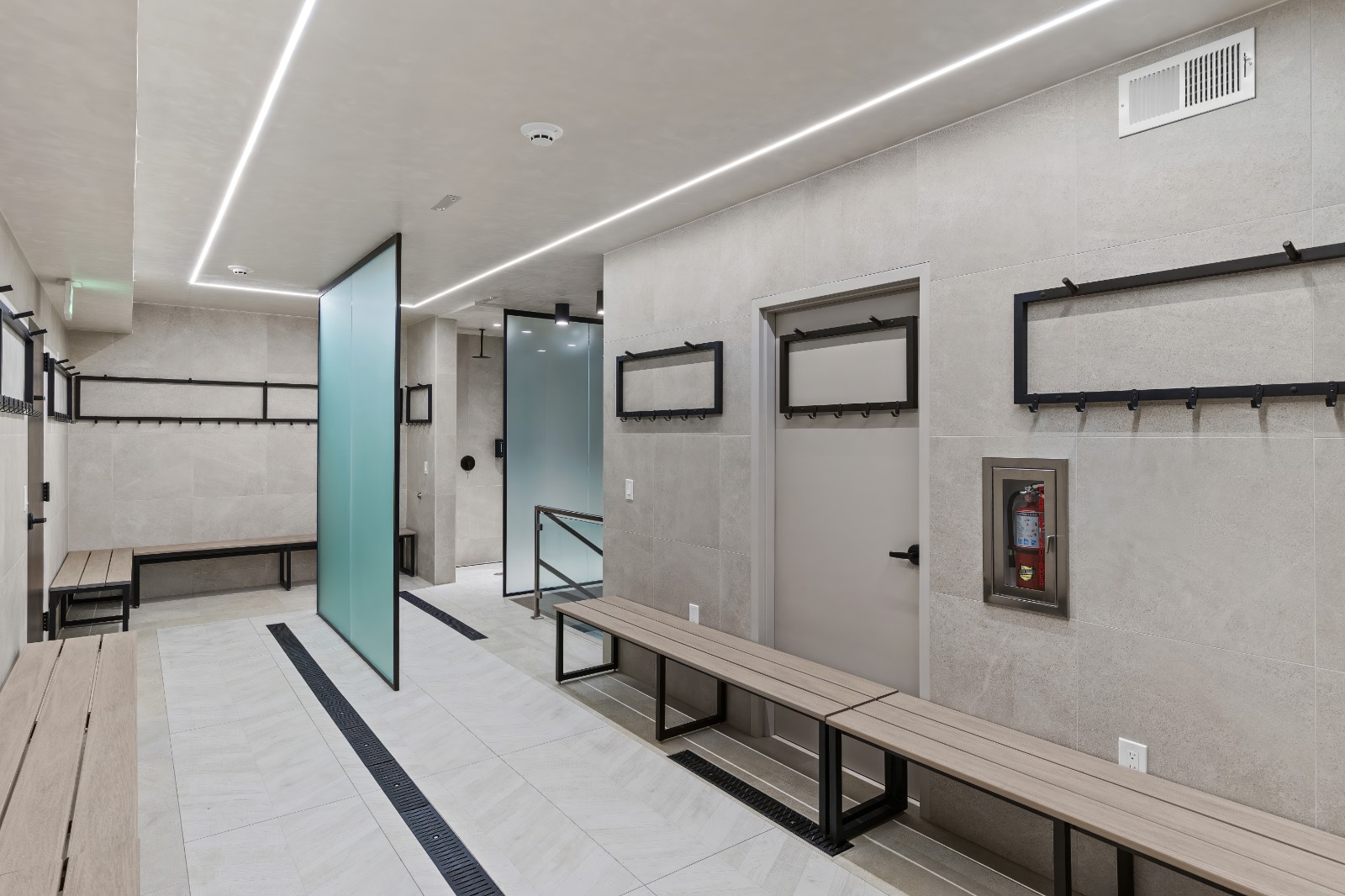 Modern locker room with LED linear ceiling lights and tiled floors