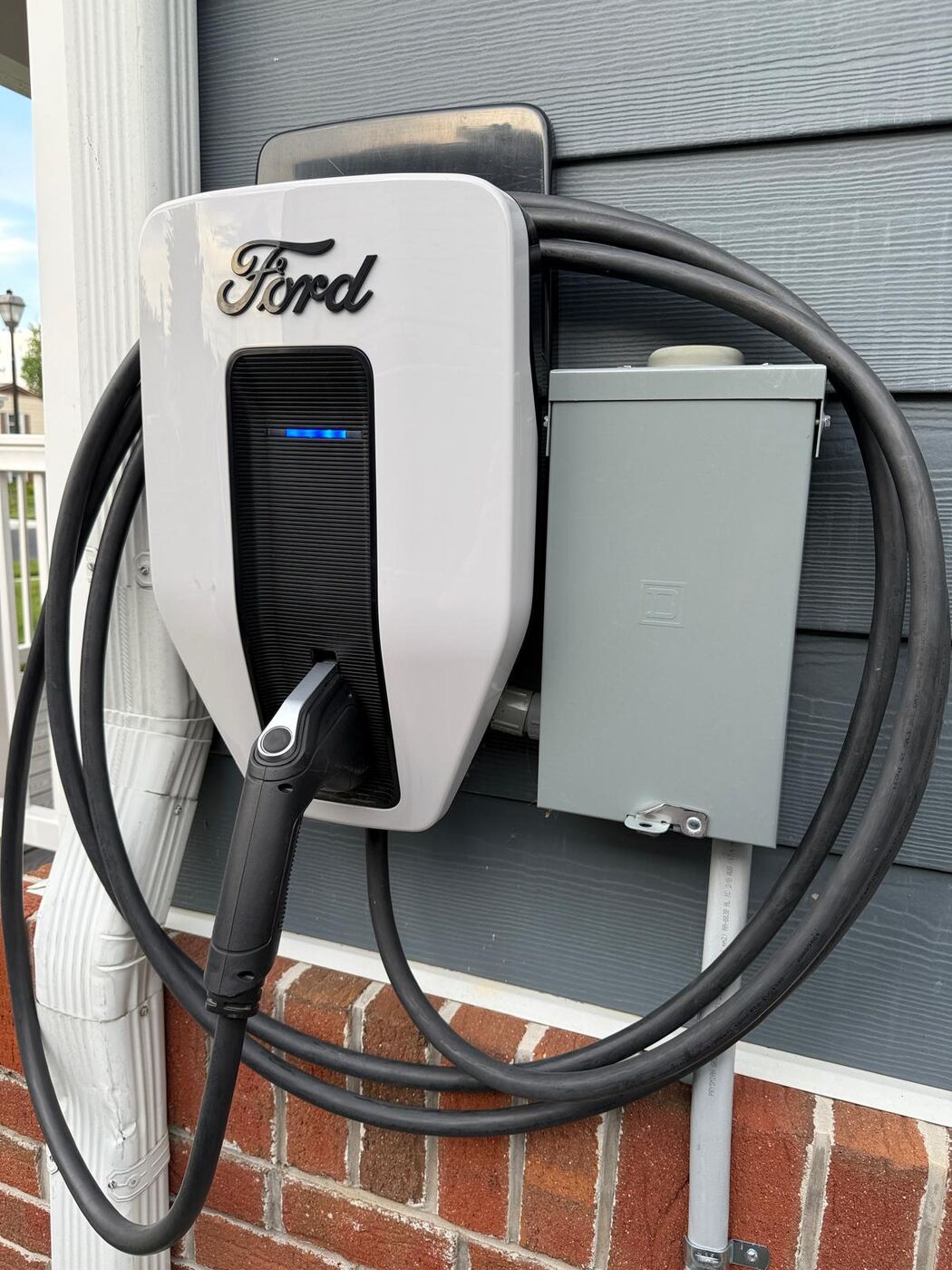 Ford wall-mounted EV charger installed on residential brick exterior
